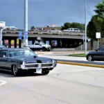 Used Dodge Charger parked in a driveway while a buyer inspects it in daylight