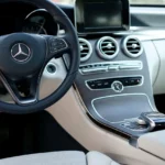 Volvo XC60 interior with driver reaching for the center touchscreen in daylight