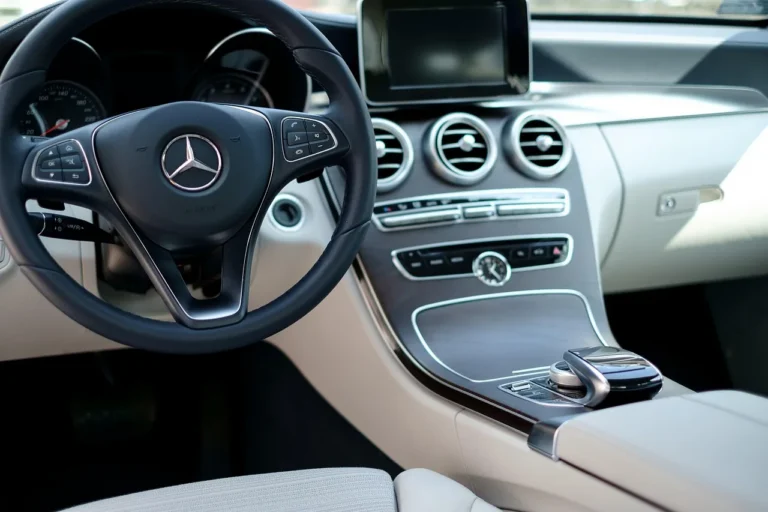 Volvo XC60 interior with driver reaching for the center touchscreen in daylight