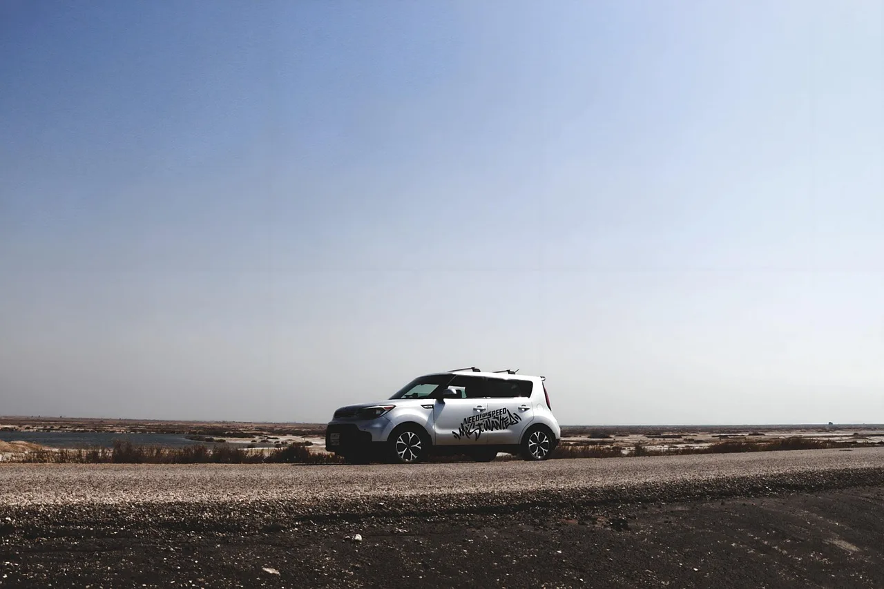Kia Soul in a used-car lot with a buyer and mechanic inspecting it in natural light