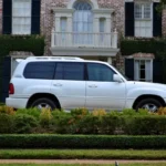 Lincoln Navigator SUV parked at a dealership while a mechanic and buyer inspect it
