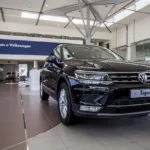 Used VW Tiguan in a dealership lot with a buyer and mechanic discussing it