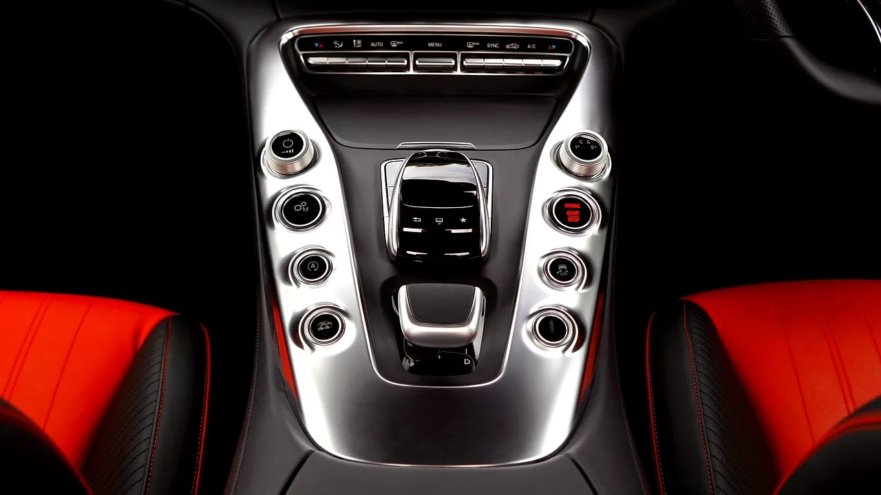 Lincoln MKX interior with driver holding a key fob near the start button and dashboard lit